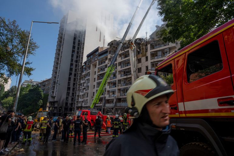 Firefighters work at the scene of a residential building following explosions in Kyiv, Ukraine, Sunday, June 26, 2022
