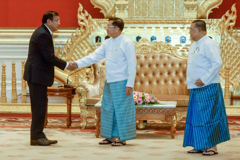 Cambodian Foreign Minister and ASEAN Special Envoy to Myanmar Prak Sokhonn (left) shakes hands with military chief Min Aung Hlaing during a visit to Myanmar in June. The military’s foreign minister is on the right. Neither have been allowed to attend ASEAN summits [Myanmar’s Foreign Ministry via AP Photo]