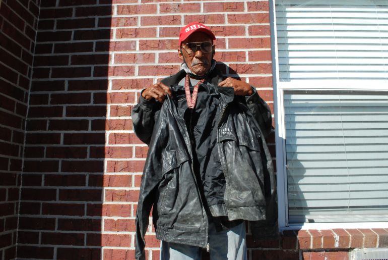 James Betts holds up a leather jacket that still bears mould and mildew, which grew over his clothes during the power outage following Hurricane Ida