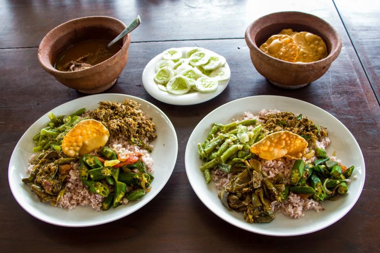 Two identical plates of food are shown, with two earthenware bols and a plate of sliced cucumber