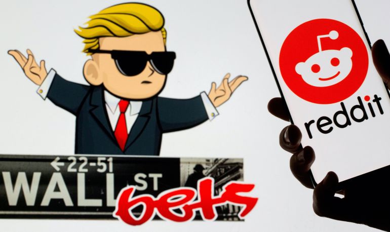 The Reddit logo is seen on a smartphone in front of a displayed Wall Street Bets logo