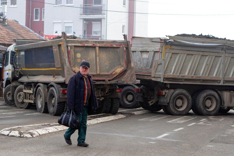 A man crosses a street near a roadblock in the northern part of the ethnically-divided town of Mitrovica, Kosovo, December 27, 2022. REUTERS/Miodrag Draskic