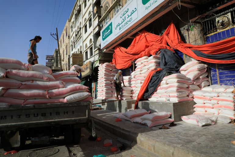 Yemeni workers carry bags of flour outside a wholesale store in Sanaa in March 2022. The country relies on imported wheat flour with nearly 50 percent of its imports coming from Ukraine and Russia in 2021