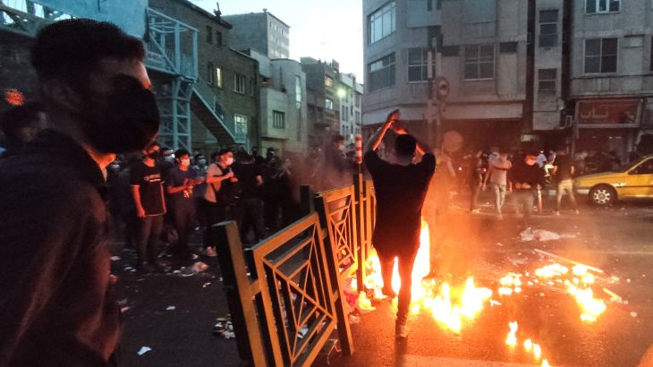 People light a fire during a protest over the death of Mahsa Amini