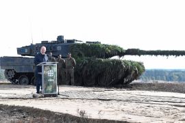 German Chancellor Olaf Scholz delivers a speech in front of a Leopard 2 tank on October 17, 2022