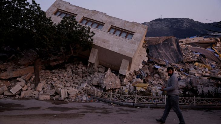 FILE PHOTO: FILE PHOTO: A man walks by a collapsed building and rubble, in the aftermath of a deadly earthquake, in Antakya, Hatay province, Turkey, February 21, 2023. REUTERS/Clodagh Kilcoyne/File Photo/File Photo