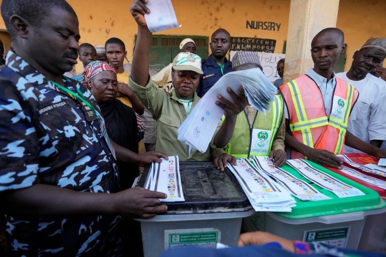 Electoral officials count ballots in front of party agents and observers at a polling station in Yola, Nigeria