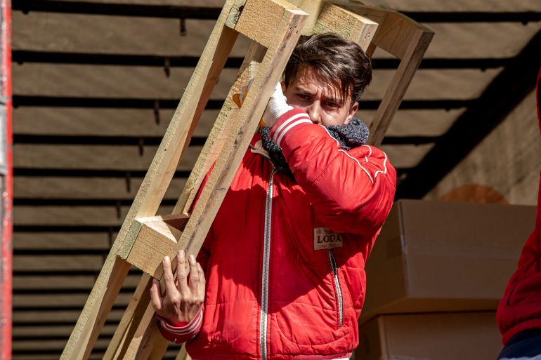 Volunteer Nidal Memik helps with tent construction