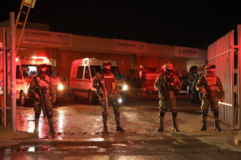 Mexican firefighters and soldiers stand during the rescue operation in Ciudad Juarez, Chihuahua state on March 27