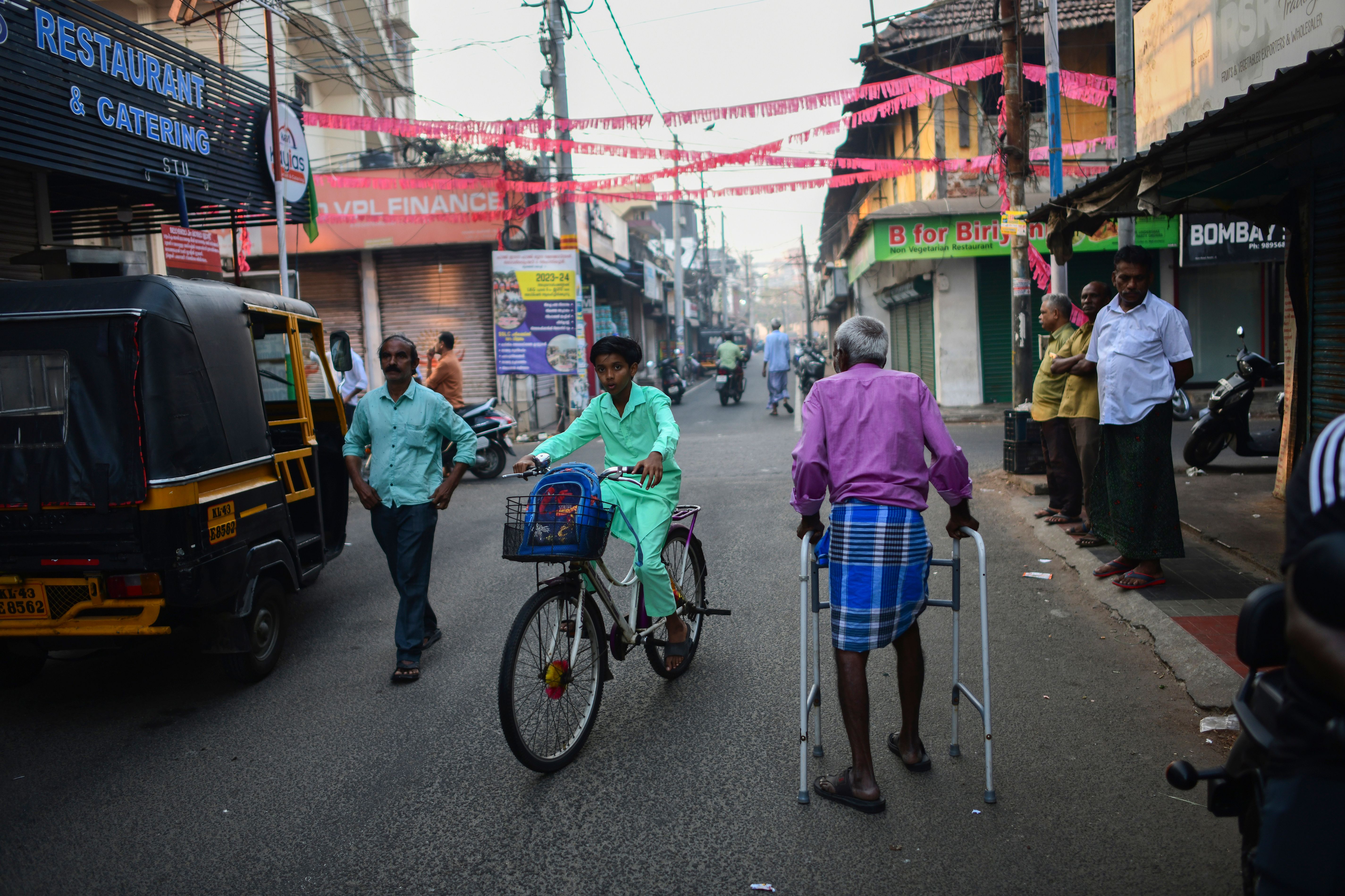 An elderly man walks through a street in Mattancherry