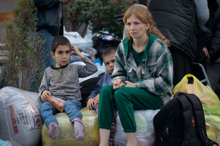 Ethnic Armenians from Nagorno-Karabakh sit after arriving in Armenia's Goris in Syunik region, Armenia
