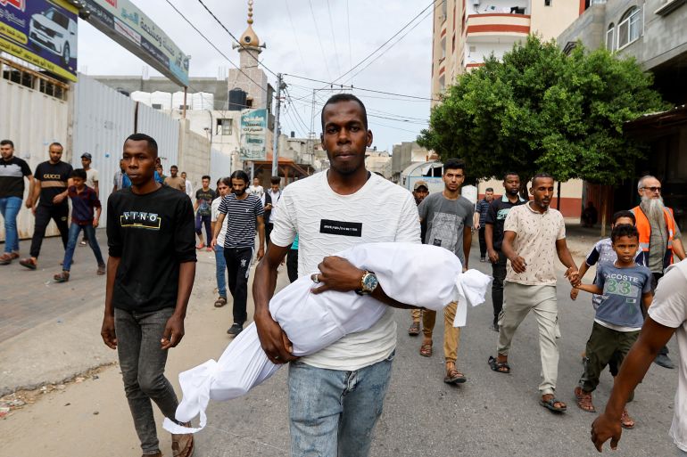 A mourner carries the body of Palestinian boy Saad Lubbad, who health officials said was killed in Israeli strikes, during his funeral in Rafah, in the southern Gaza Strip, October 9, 2023. REUTERS/Ibraheem Abu Mustafa