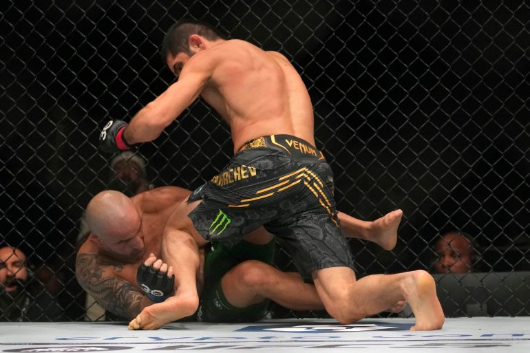 Islam Makhachev of Russia, on top, battles Alex Volkanovski