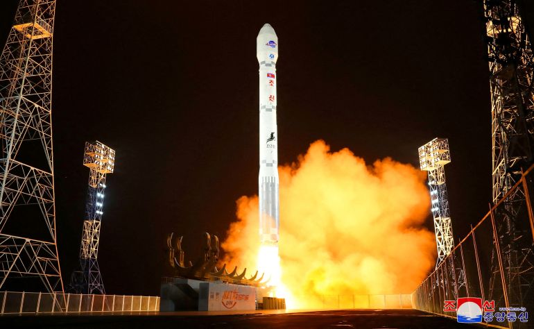 The rocket taking off in amid orange smoke and flame