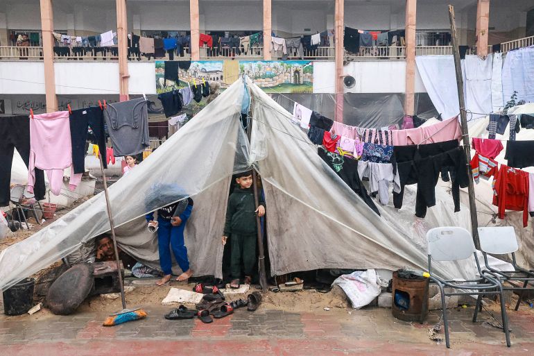 Palestinian boys stand in a makeshift tent at a camp in Rafah in the southern Gaza Strip