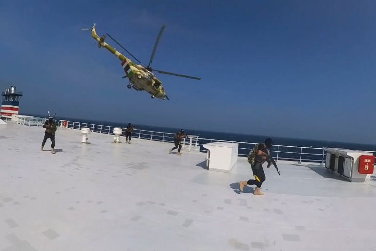 This photo released by the Houthi Media Center shows Houthi forces boarding the cargo ship Galaxy Leader on Sunday, Nov. 19, 2023. Yemen's Houthis have seized the ship in the Red Sea off the coast of Yemen after threatening to seize all vessels owned by Israeli companies. (Houthi Media Center via AP)