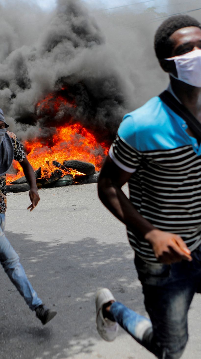 People run during a protest demanding an end to gang violence in Haiti