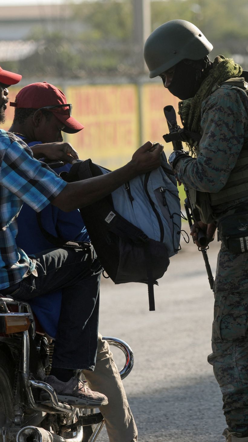 A soldier checks a bag for weapons in Haiti