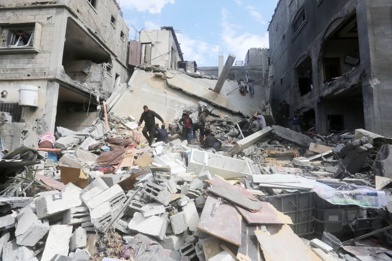 Palestinians gather to inspect a destroyed building following an Israeli attack on Deir el-Balah on March 8