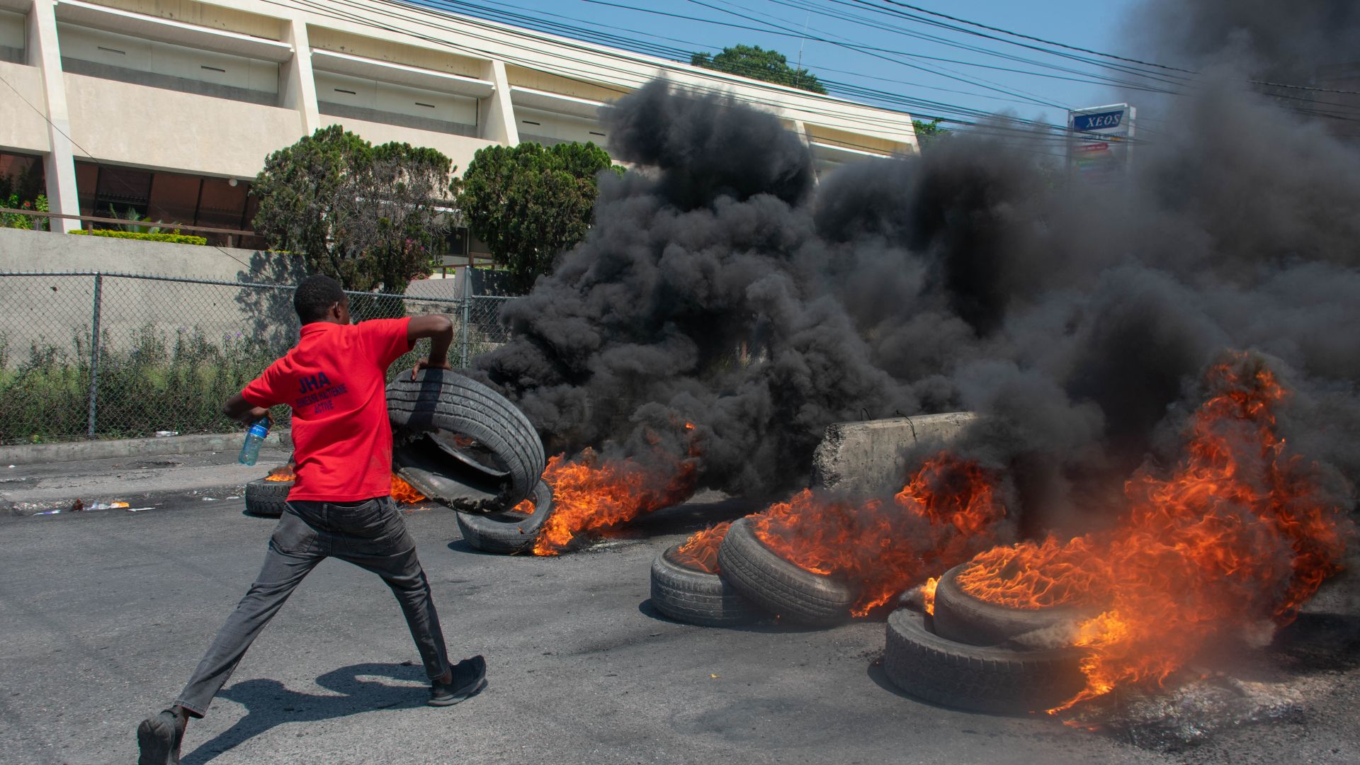 A protester burns tires during a demonstration following the resignation of its Prime Minister Ariel Henry, in Port-au-Prince, Haiti, on March 12