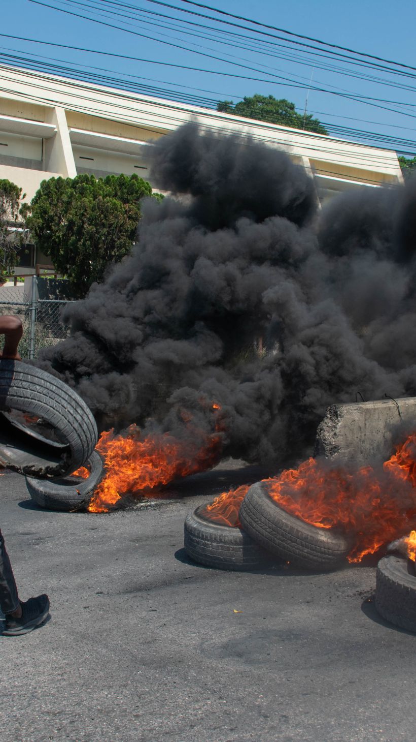 A protester burns tires during a demonstration following the resignation of its Prime Minister Ariel Henry, in Port-au-Prince, Haiti, on March 12