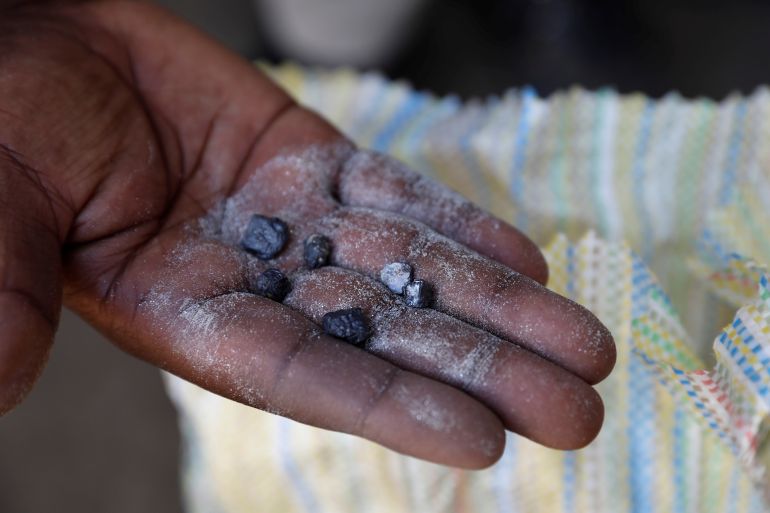 A man displays coltan rocks at the SMB mine near the town of Rubaya in the Eastern Democratic Republic of the Congo, on August 13, 2019