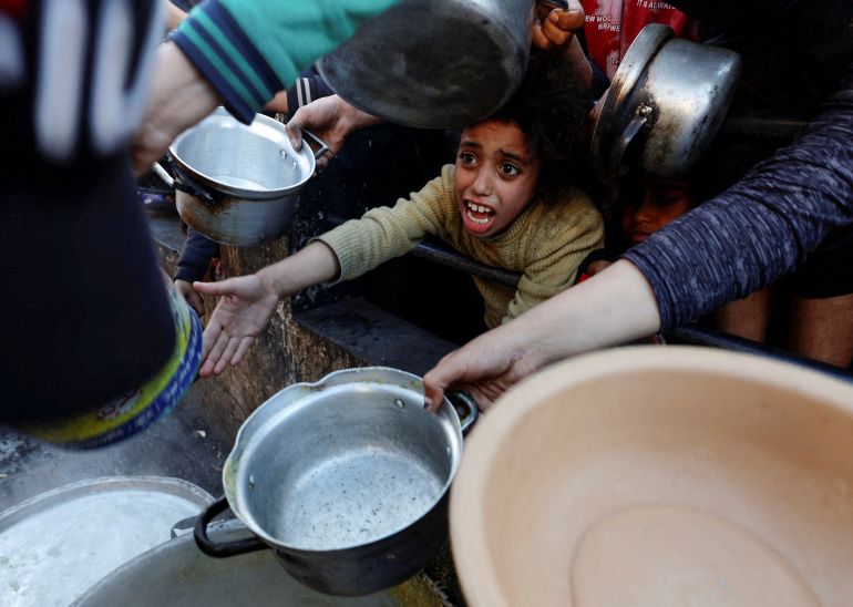 Palestinians wait to receive food during the Muslim fasting month of Ramadan