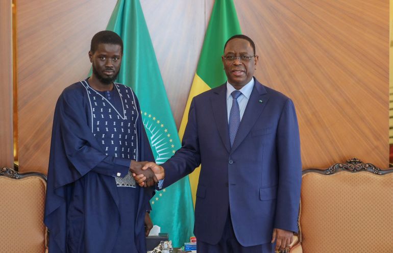 Senegal’s new president, Bassirou Diomaye Faye, left, shakes hands with the outgoing president, Macky Sall