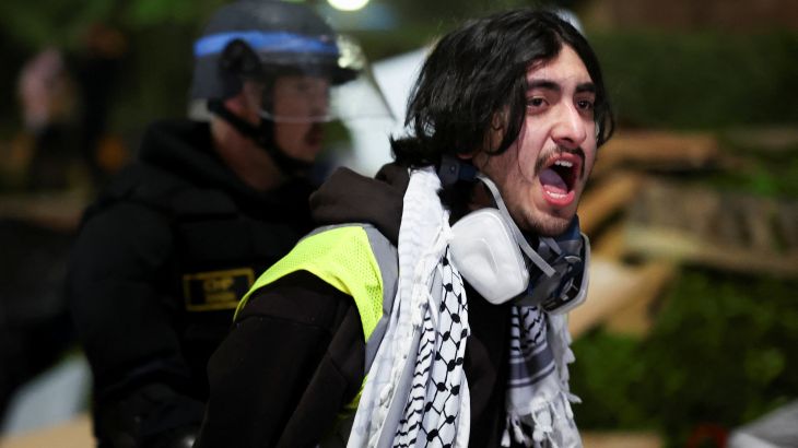 A protester reacts next to a law enforcement officer at the University of California Los Angeles (UCLA)