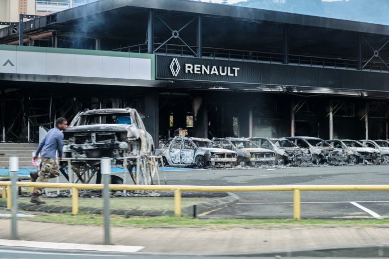 Charred cars and the remains of a Renault store amid riots in Noumea, New Caledonia
