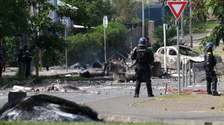 A French gendarme on the street in Noumea. There is debris around him.