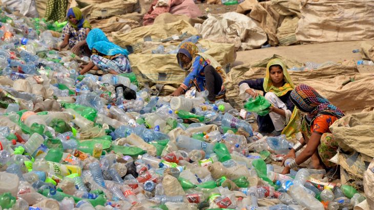 Pakistani laborers, mostly women, sort through empty bottles at a plastic recycling factory in Hyderabad, Pakistan.