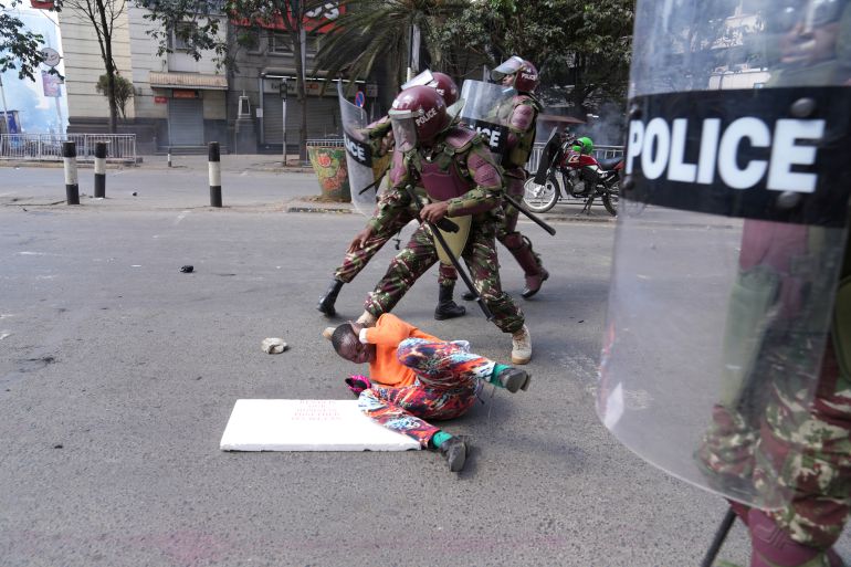 Kenya police take on a man during a protest over proposed tax hikes in a finance bill, in downtown Nairobi, Kenya on Tuesday, June 25, 2024