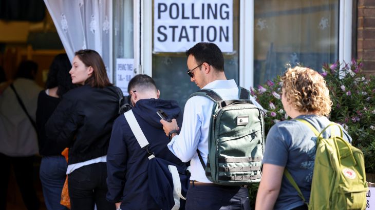 People queue to vote at a polling station during the general election in London, Britain