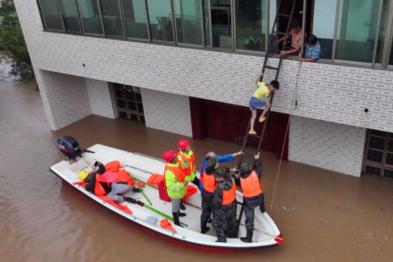 A drone view shows rescue workers evacuating residents stranded by floodwaters following heavy rainfall in the region, in Caoshi town of Hengyang, Hunan province,