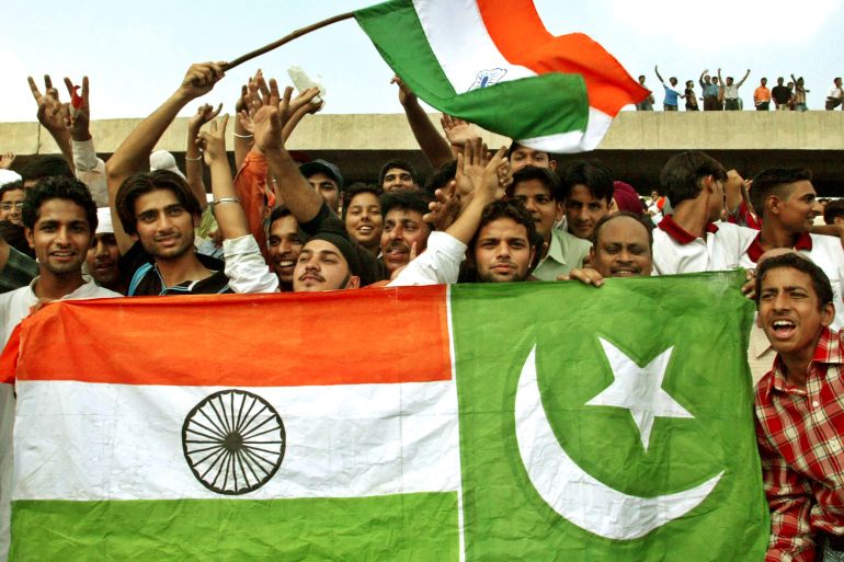 Field hockey fans hold Indian and Pakistan national flags as they cheer for Indian and Pakistani players during their field hockey match in the northern Indian city of Chandigarh October 6, 2004. The match ended in a 1-1 draw. REUTERS/Ajay Verma AH/CP