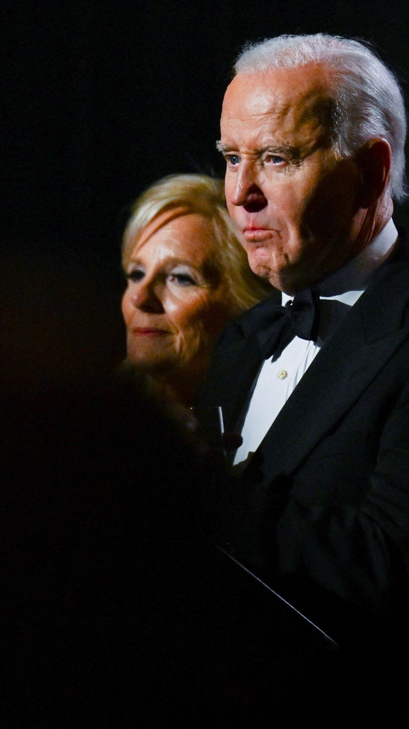 Joe Biden and Jill Biden, their faces lit in the dark.