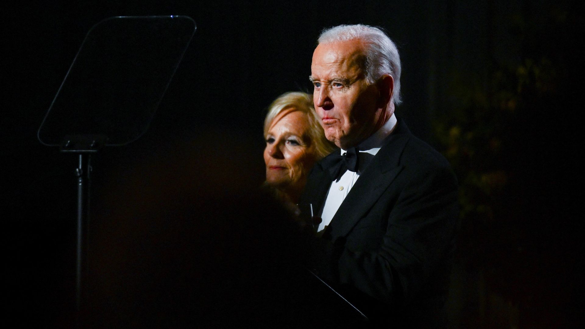 Joe Biden and Jill Biden, their faces lit in the dark.