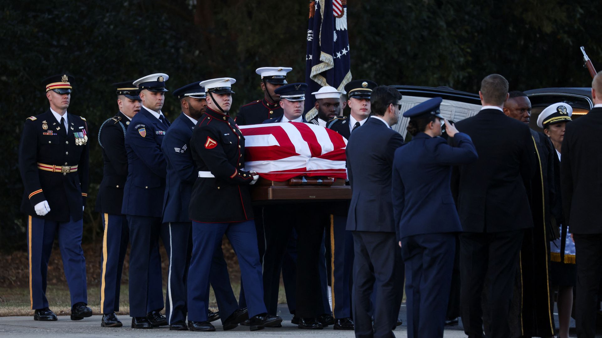 Soldiers carry the flag-draped casket of Jimmy Carter