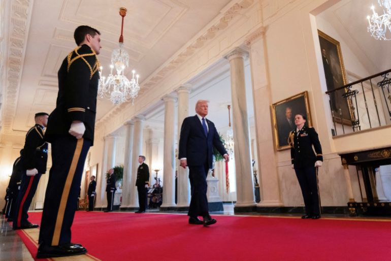 President Donald Trump walks through a White House hall to an event to publicly sign the Laken Riley Act