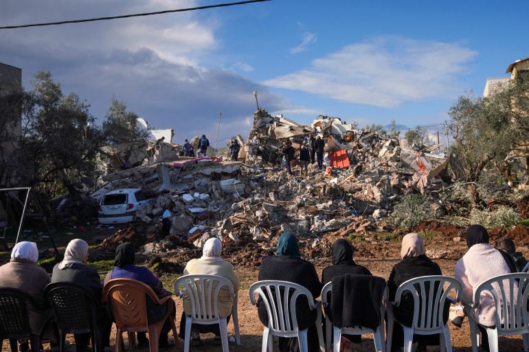 Palestinian women sit across from the rubble of a house after an Israeli raid in Burqin village near Jenin in the occupied West Bank [AFP]