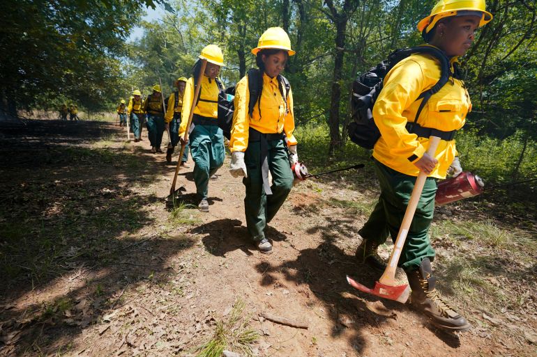 Students make their way through a forest during a wildland firefighter training session on Friday, June 9, 2023, in Hazel Green, Alabama