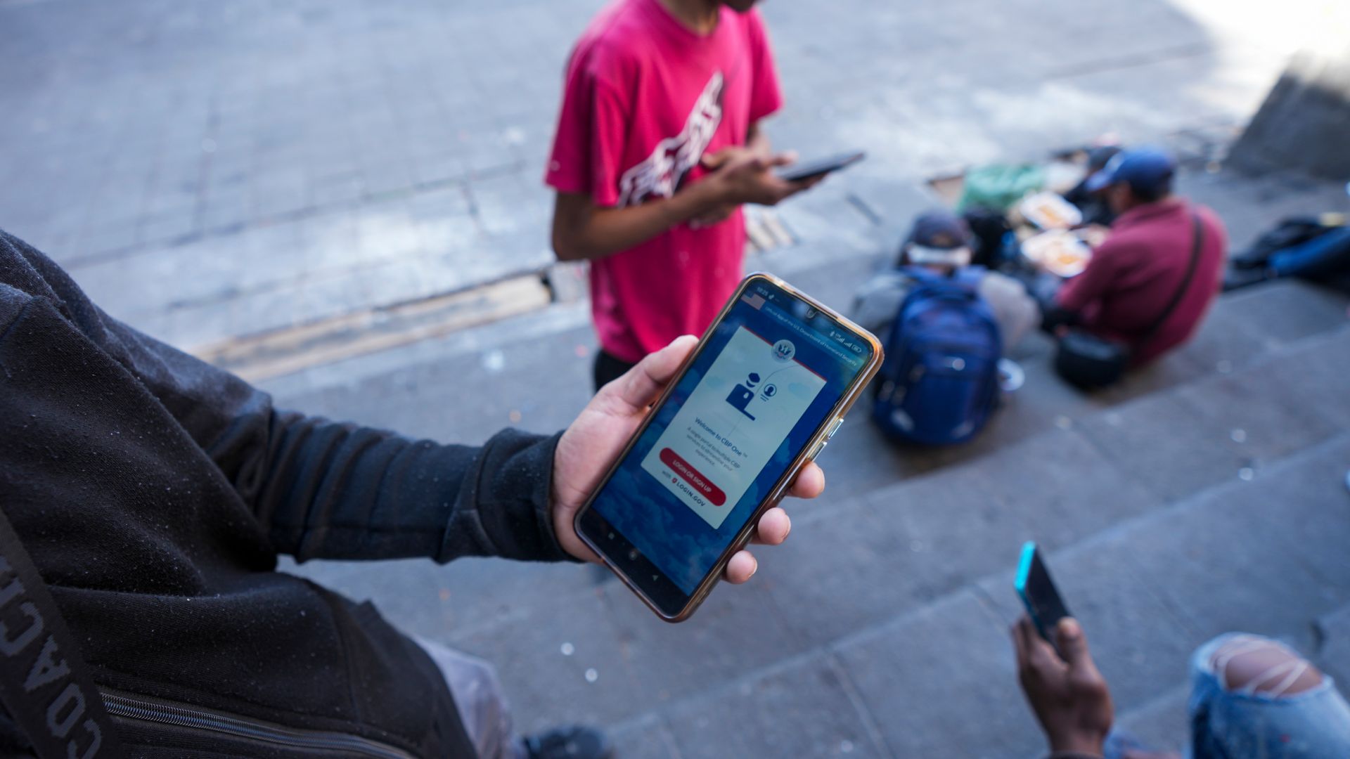 A person holds a phone with CBP One app