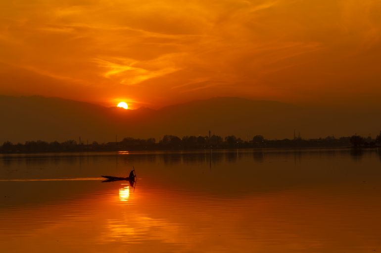 A Kashmiri fisherman rows his traditional wooden boat at Dal Lake, Srinagar