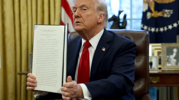 Donald Trump holds up an executive order