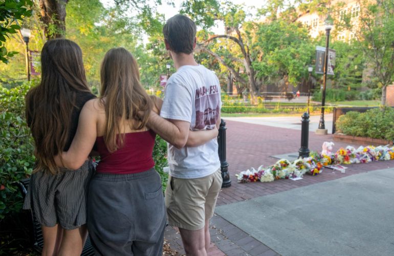 People gather at a makeshift memorial near the scene of a shooting on the Florida State University campus in Tallahassee, Florida, on April 17