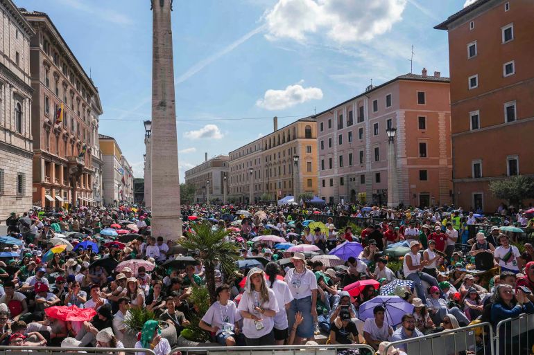 Faithful shade from the sun, with umbrellas as they attend a holy mass a day after the funeral of Pope Francis