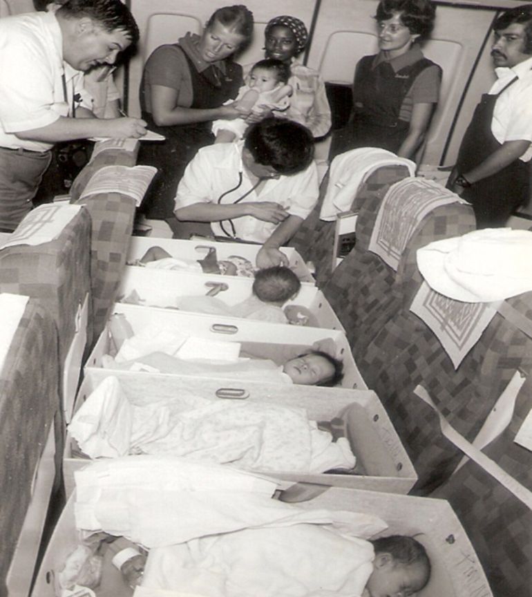 Vietnamese adoptees are checked by a doctor after being placed in file boxes and secured to seats on the plane [Courtesy of Frederick Burkle]