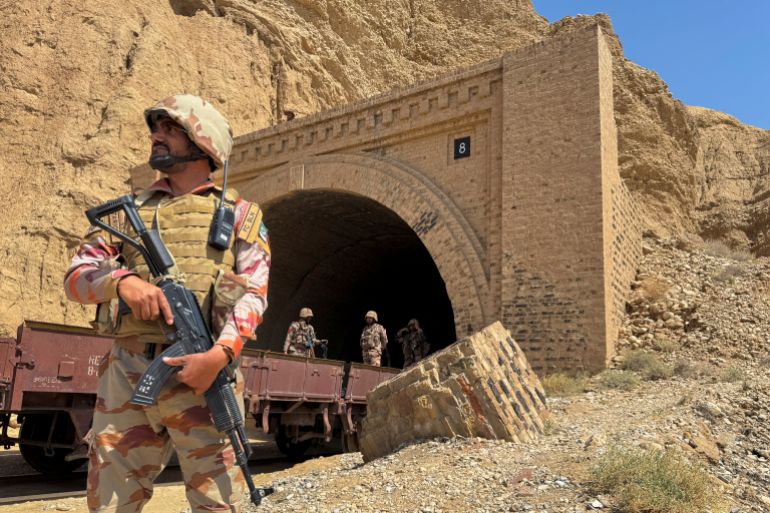 Pakistani soldiers stand outside a tunnel where a train was attacked by secessionist fighters in Bolan, Balochistan, on March 15, 2025