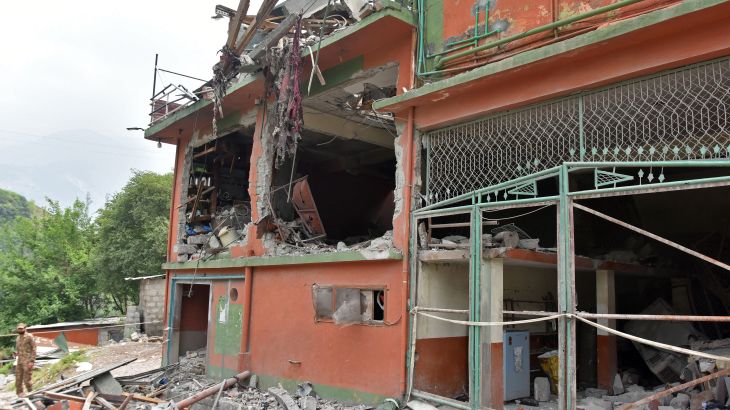 A soldier inspects the debris of a mosque after Indian strikes